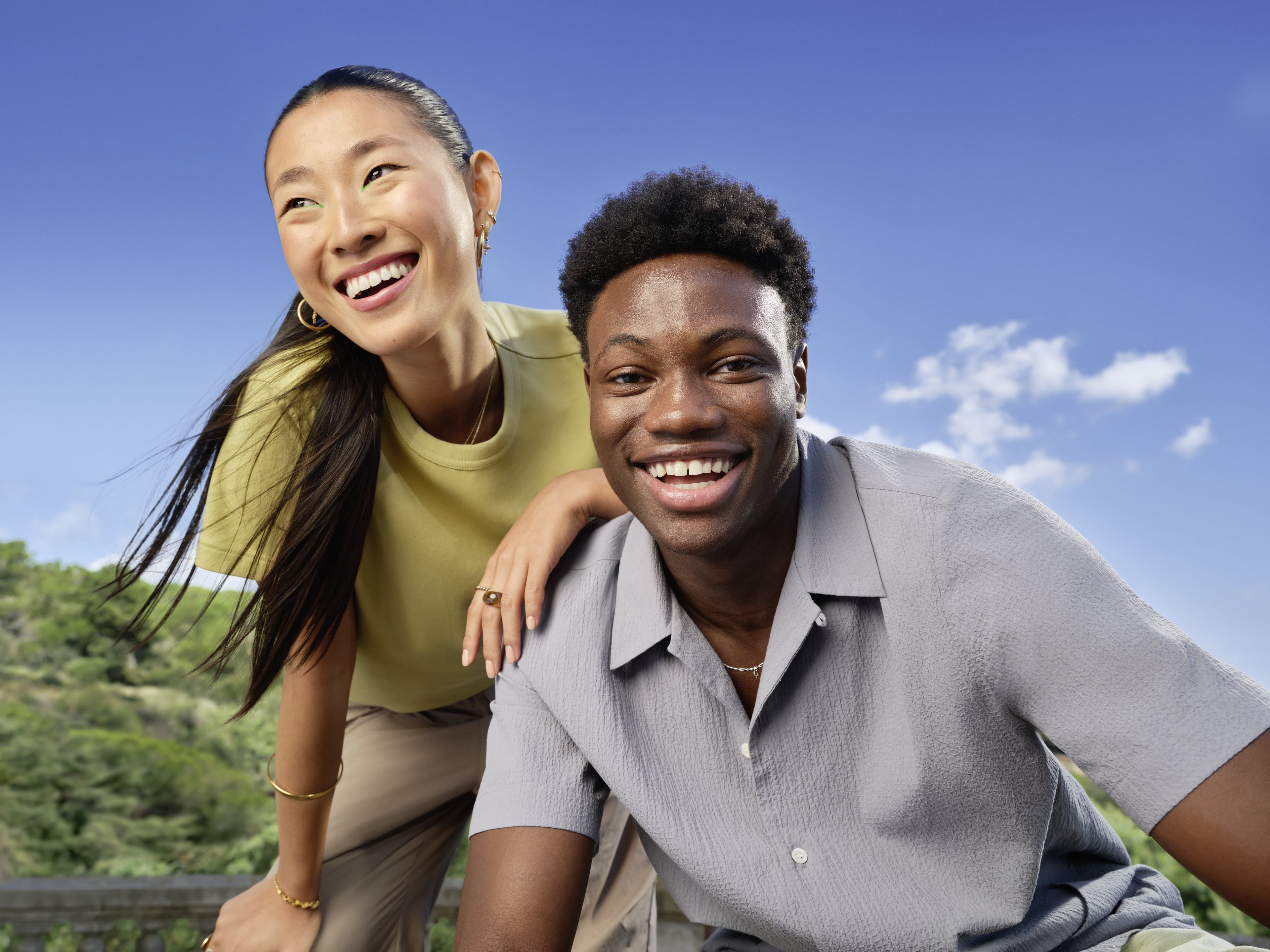 A smiling man and woman in front of a bright blue sky