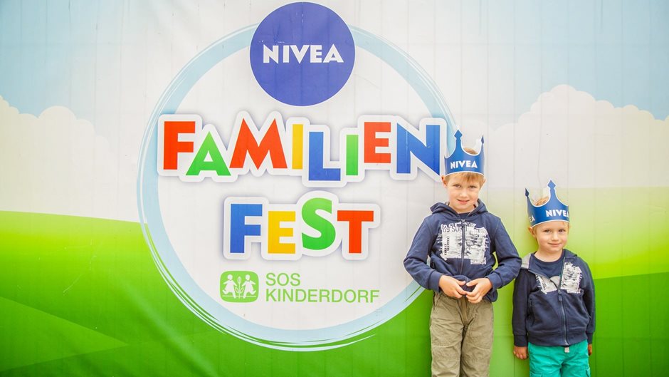 two boys in front of NIVEA family parties poster