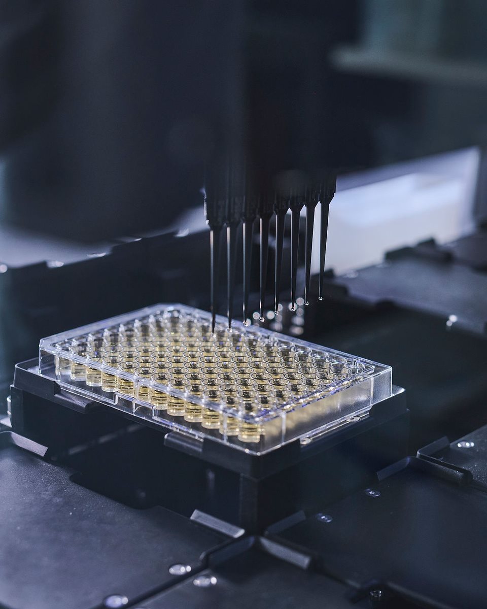 Automated laboratory pipetting system dispensing liquid into a multiwell plate, illustrating high-throughput scientific testing and analysis.