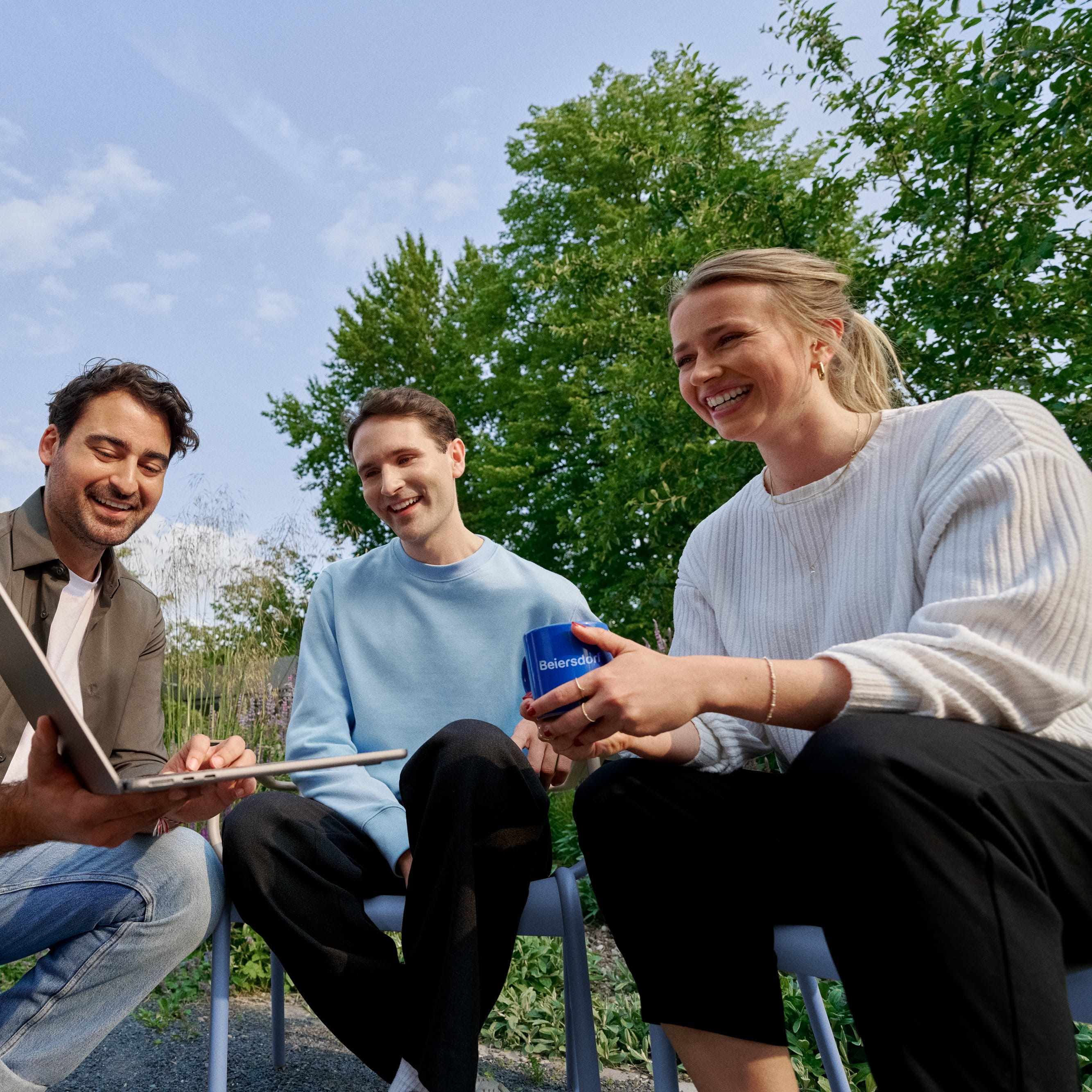 Beiersdorf employees collaborating outdoors on a shared project, demonstrating teamwork, flexibility and a modern work environment.