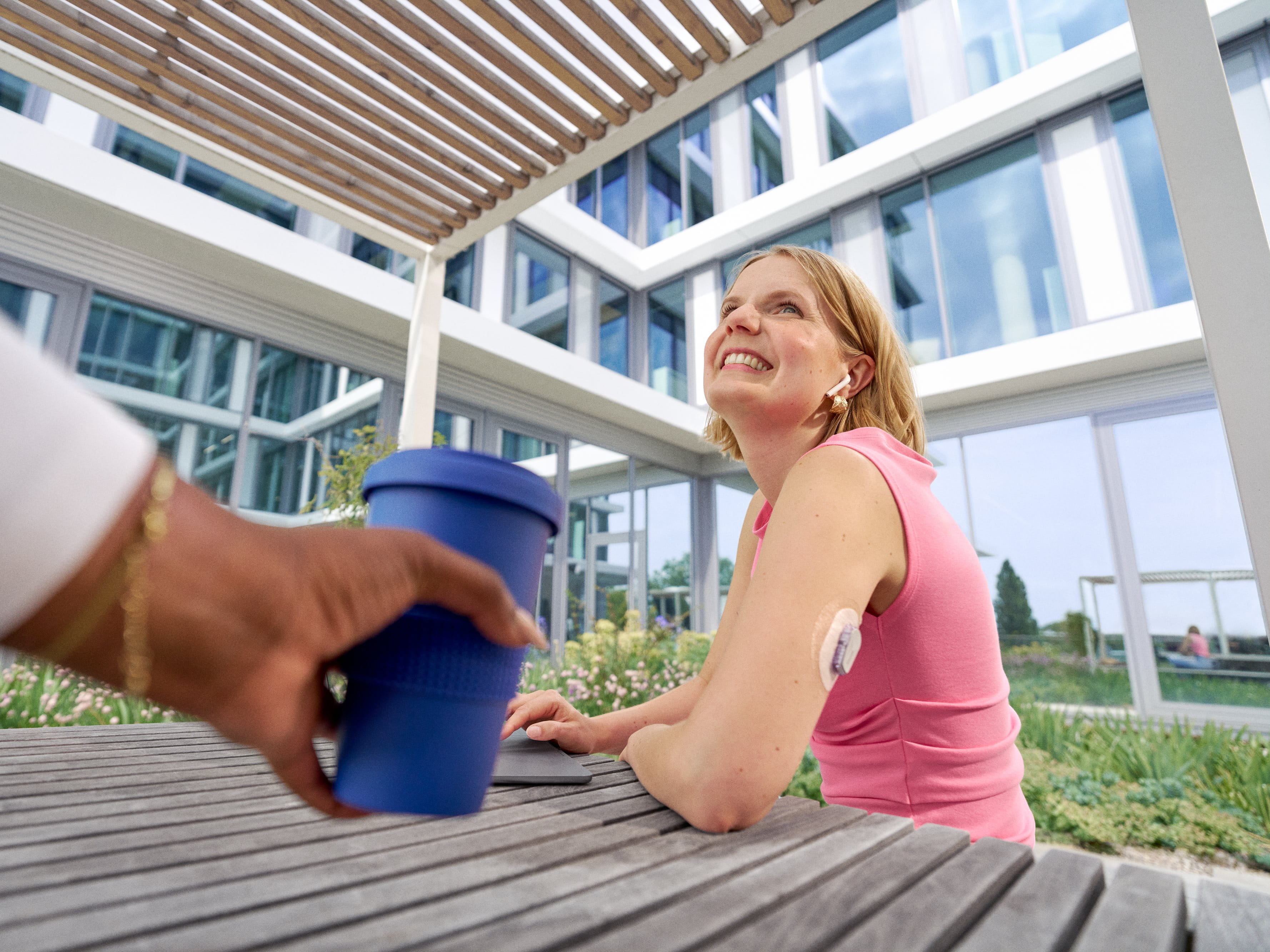 Beiersdorf employee enjoying a break outdoors while wearing a health monitoring device, representing employee well-being and workplace health.