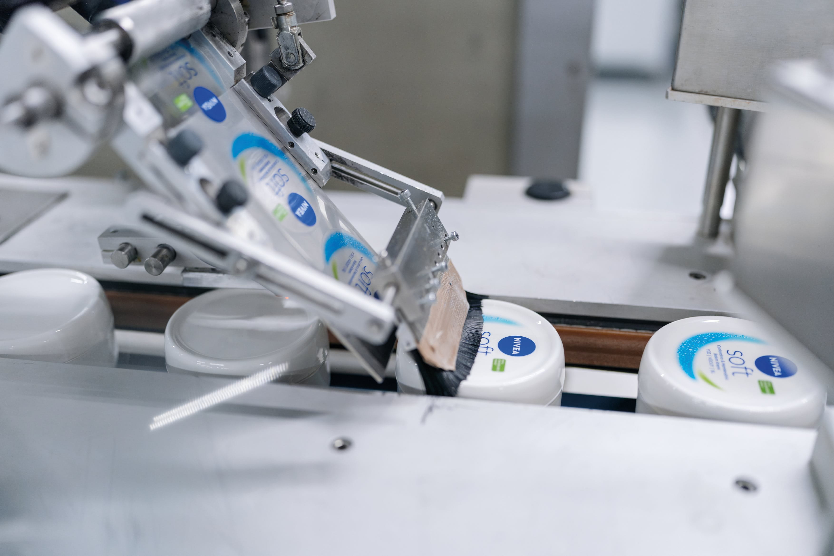 Close-up of shredded plastic fragments in mixed colors (blue, white, teal, and orange), representing recycled plastic material.