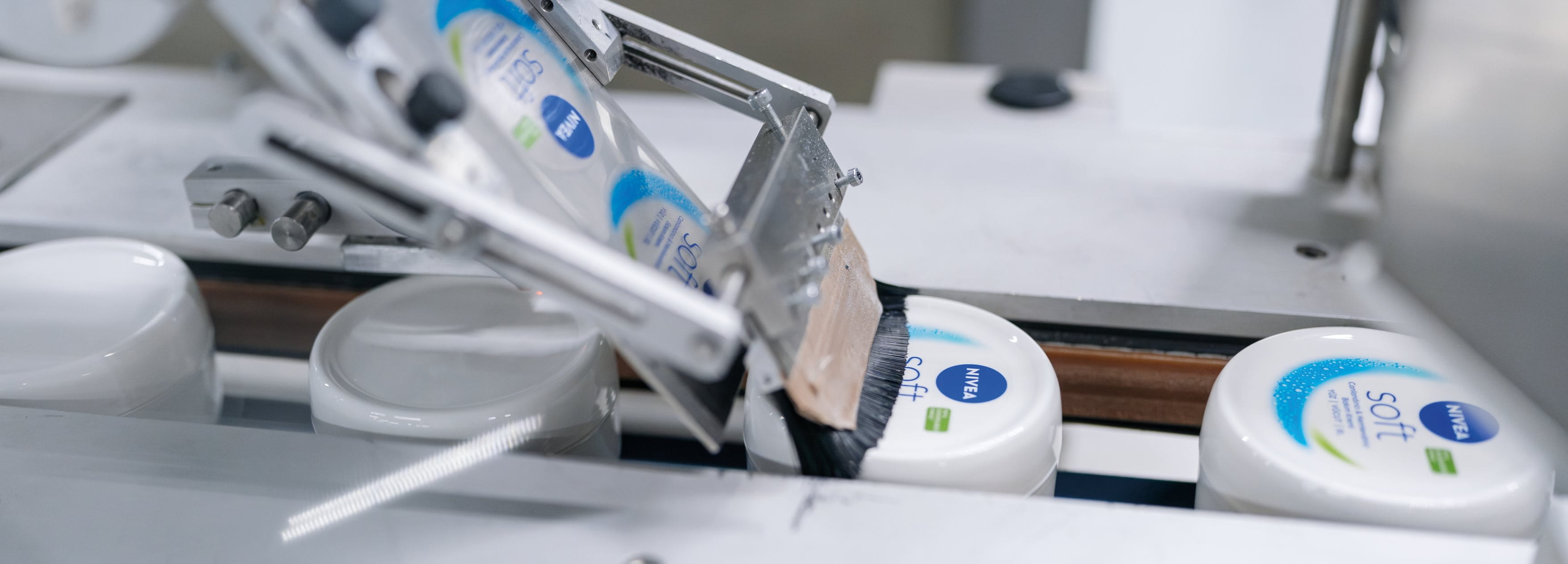 Close-up of shredded plastic fragments in mixed colors (blue, white, teal, and orange), representing recycled plastic material.