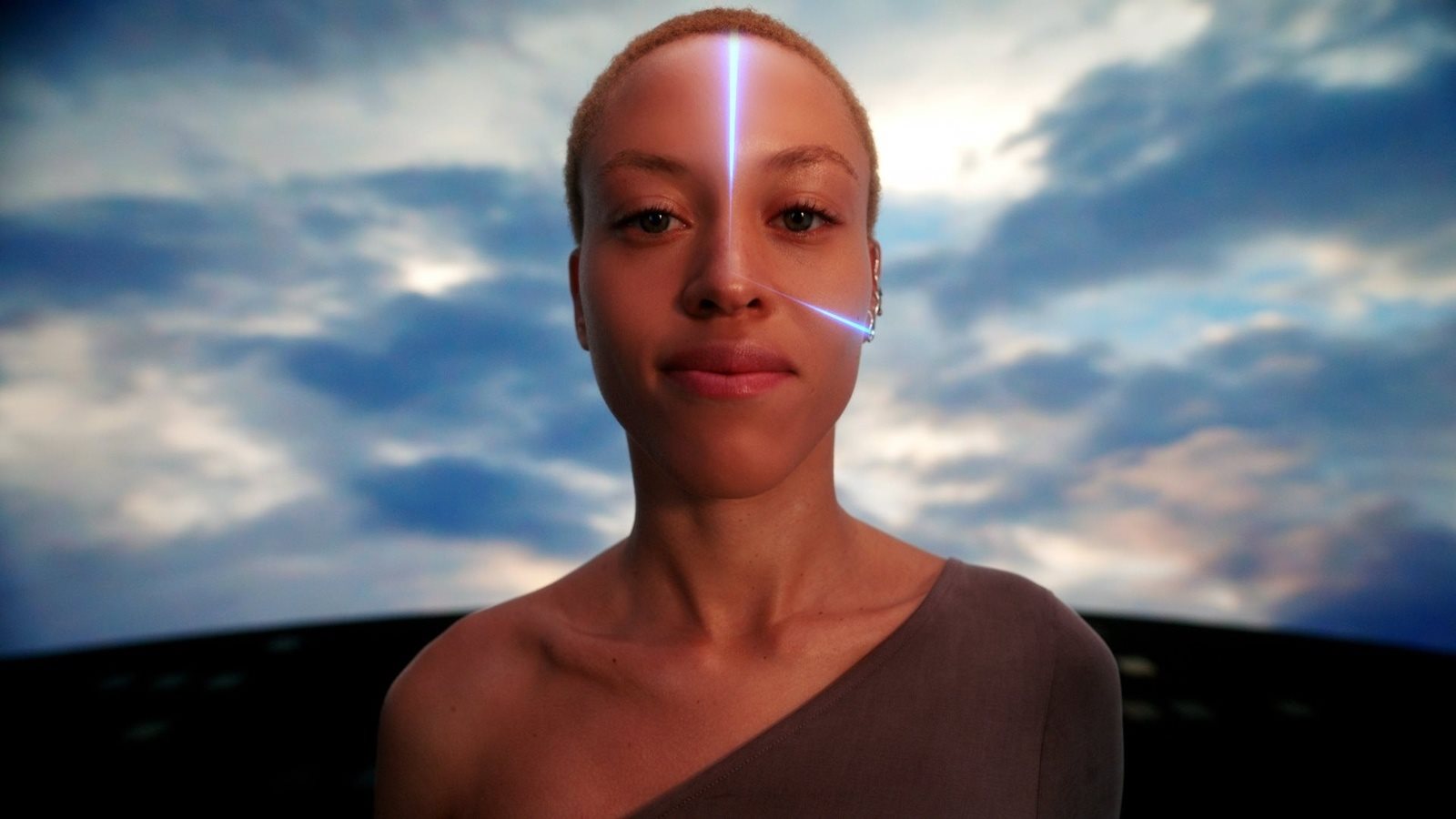 Person with glowing blue lines on their face against a cloudy sky.