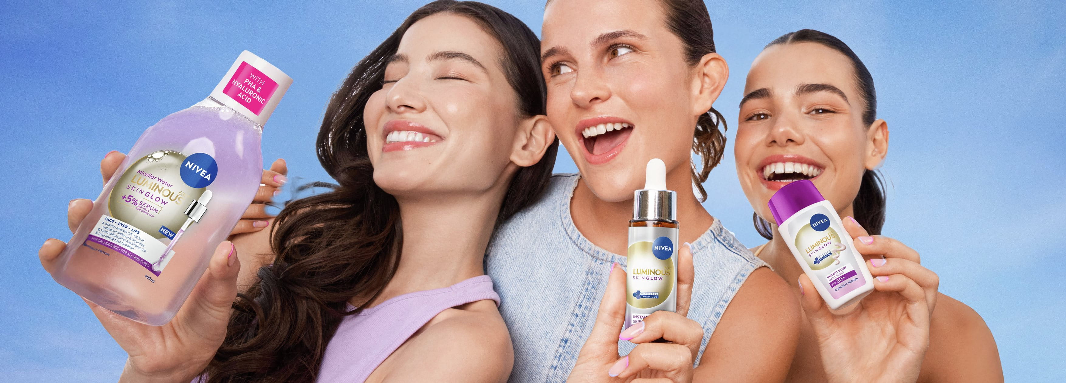 Group of friends smiling closely together outdoors, with one person holding up a NIVEA skincare product bottle, conveying joy, confidence, and shared moments.