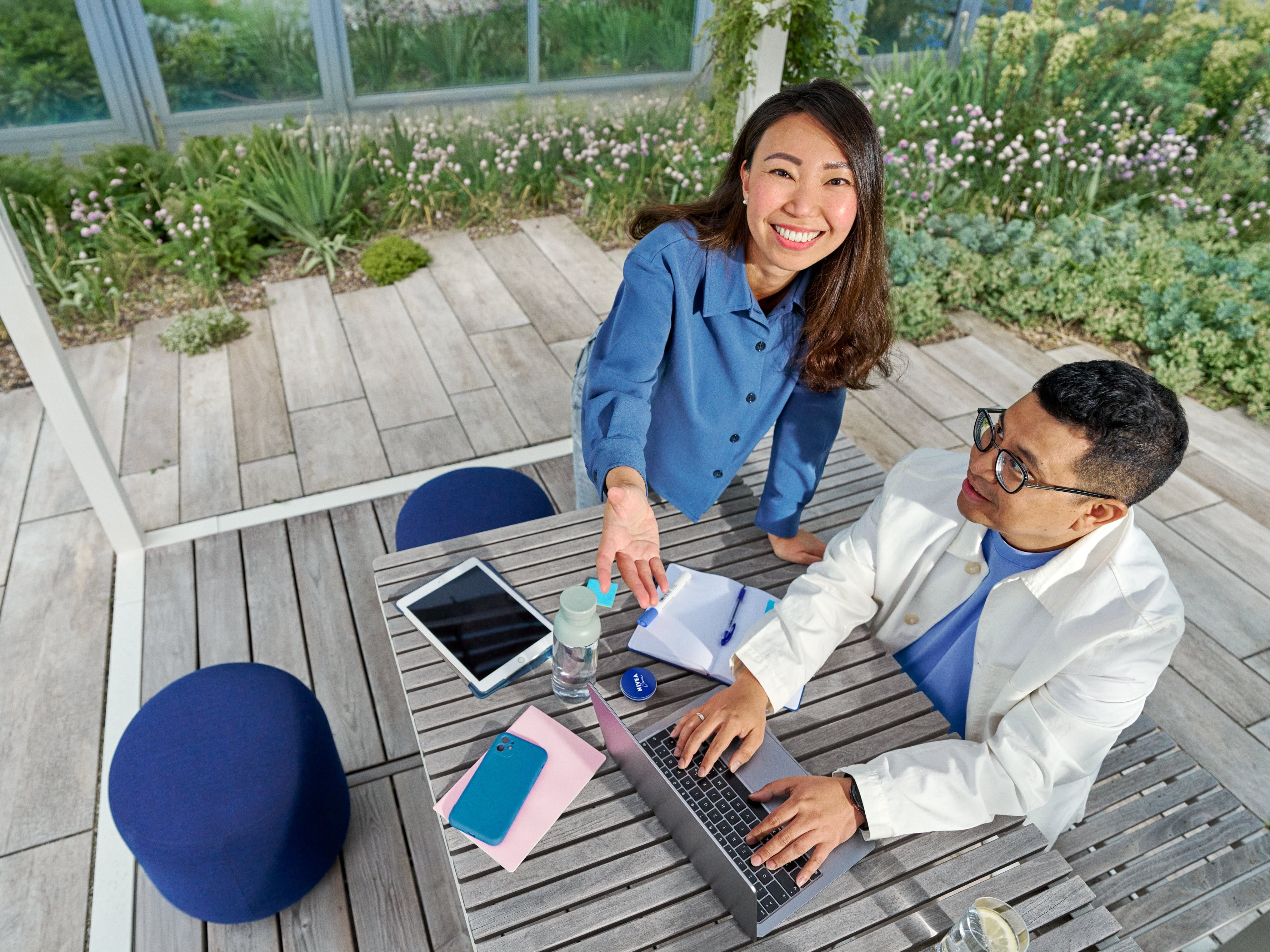 Beiersdorf employees collaborating in an outdoor workspace, combining teamwork, innovation and flexible working in a modern office environment.