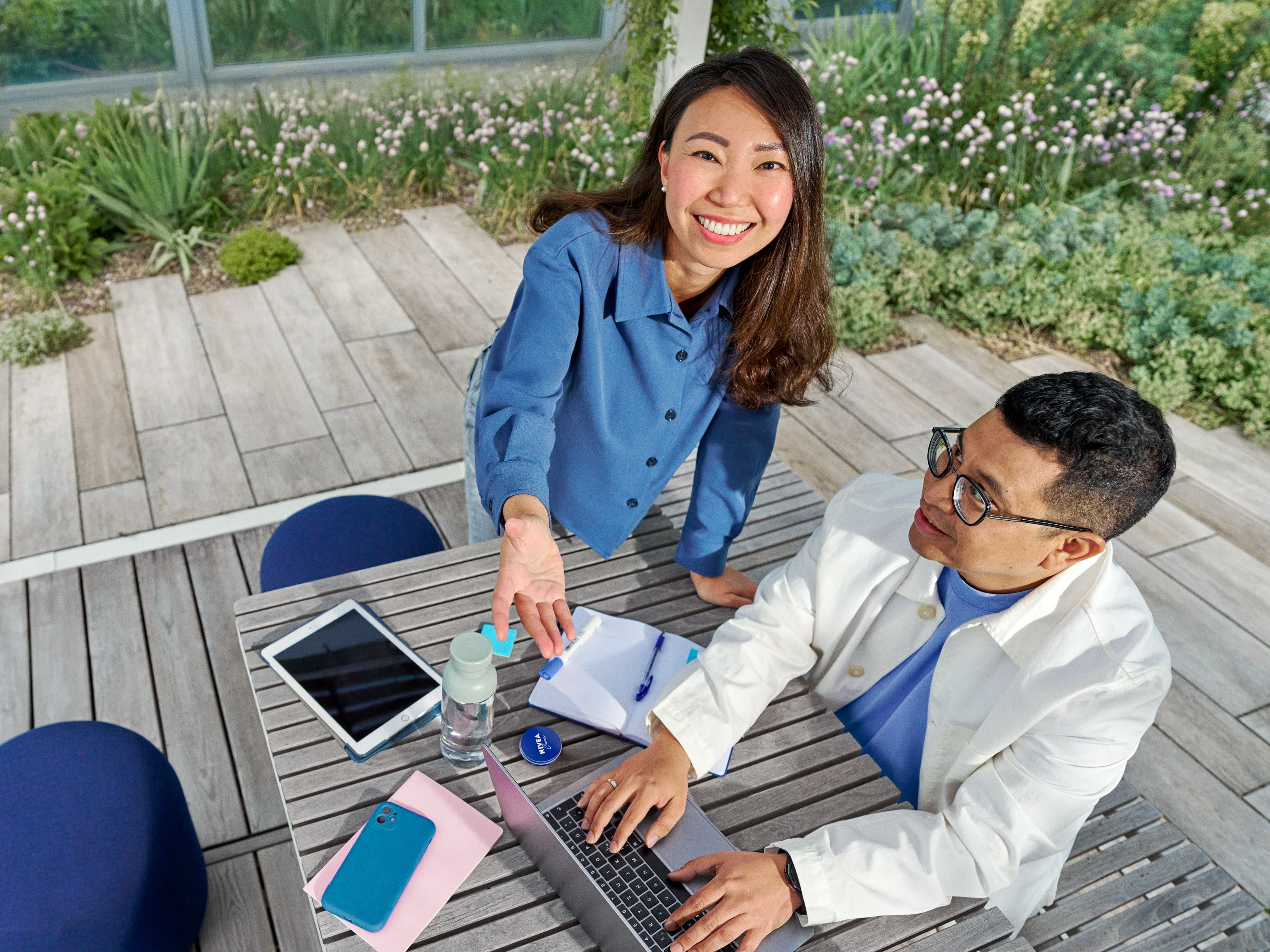 Beiersdorf employees collaborating in an outdoor workspace, combining teamwork, innovation and flexible working in a modern office environment.