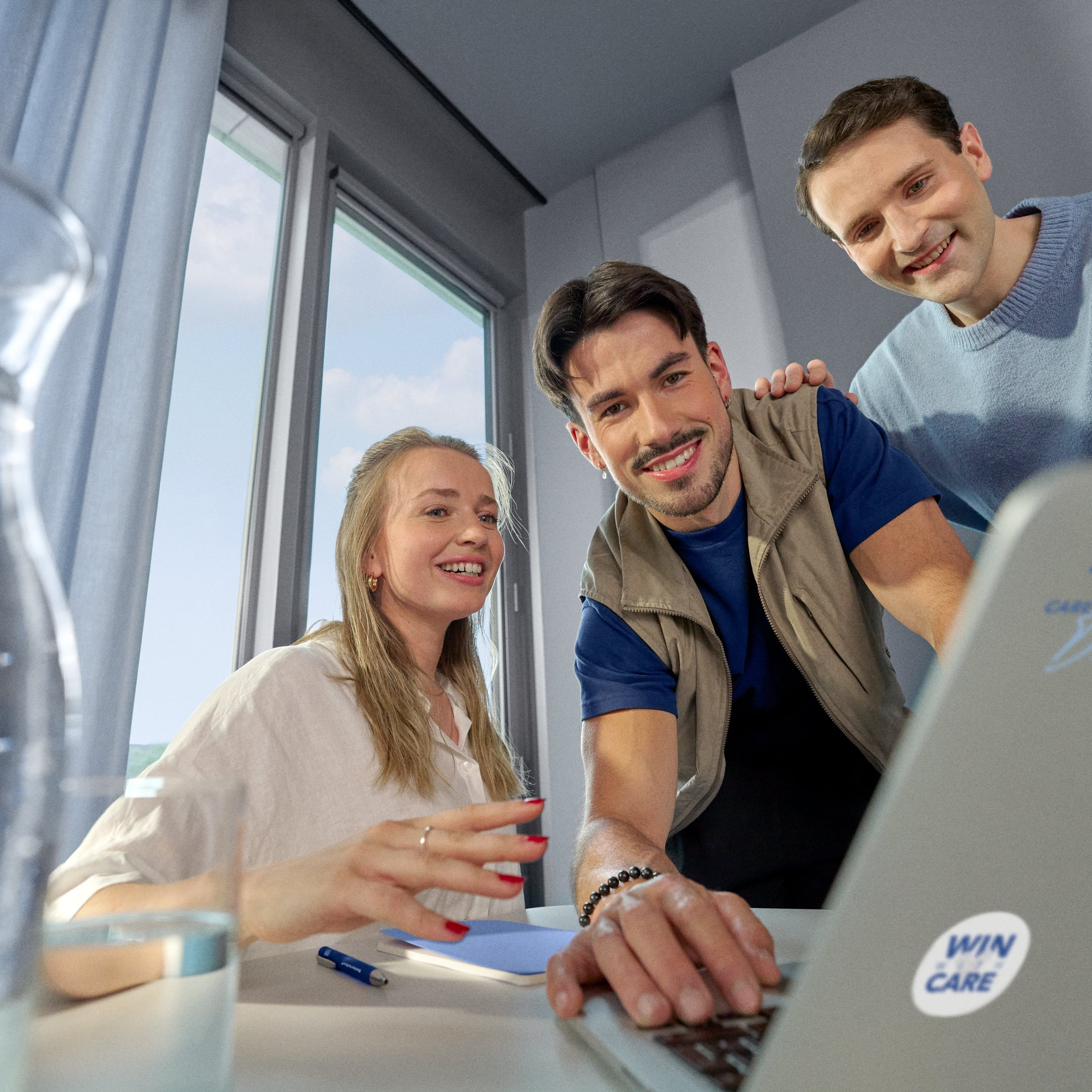 Beiersdorf employees reviewing project work on a laptop, highlighting collaboration, innovation and career opportunities within a global team.